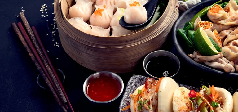 Chinese dumplings and dim sum on dark background