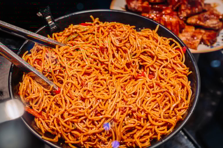 Stir-fried noodles and vegetables in lively dining environment